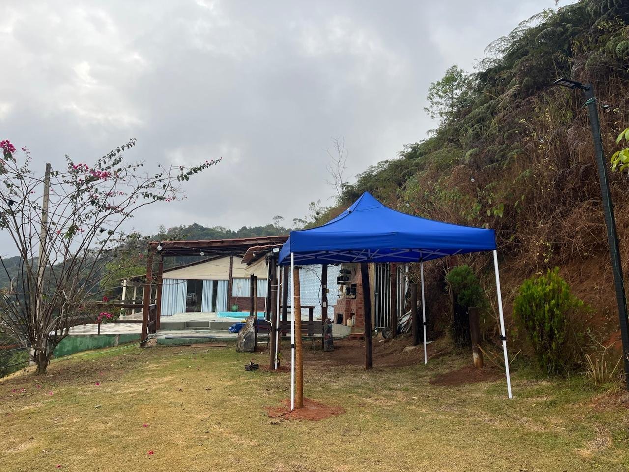 Área externa da pousada com tenda e gramado