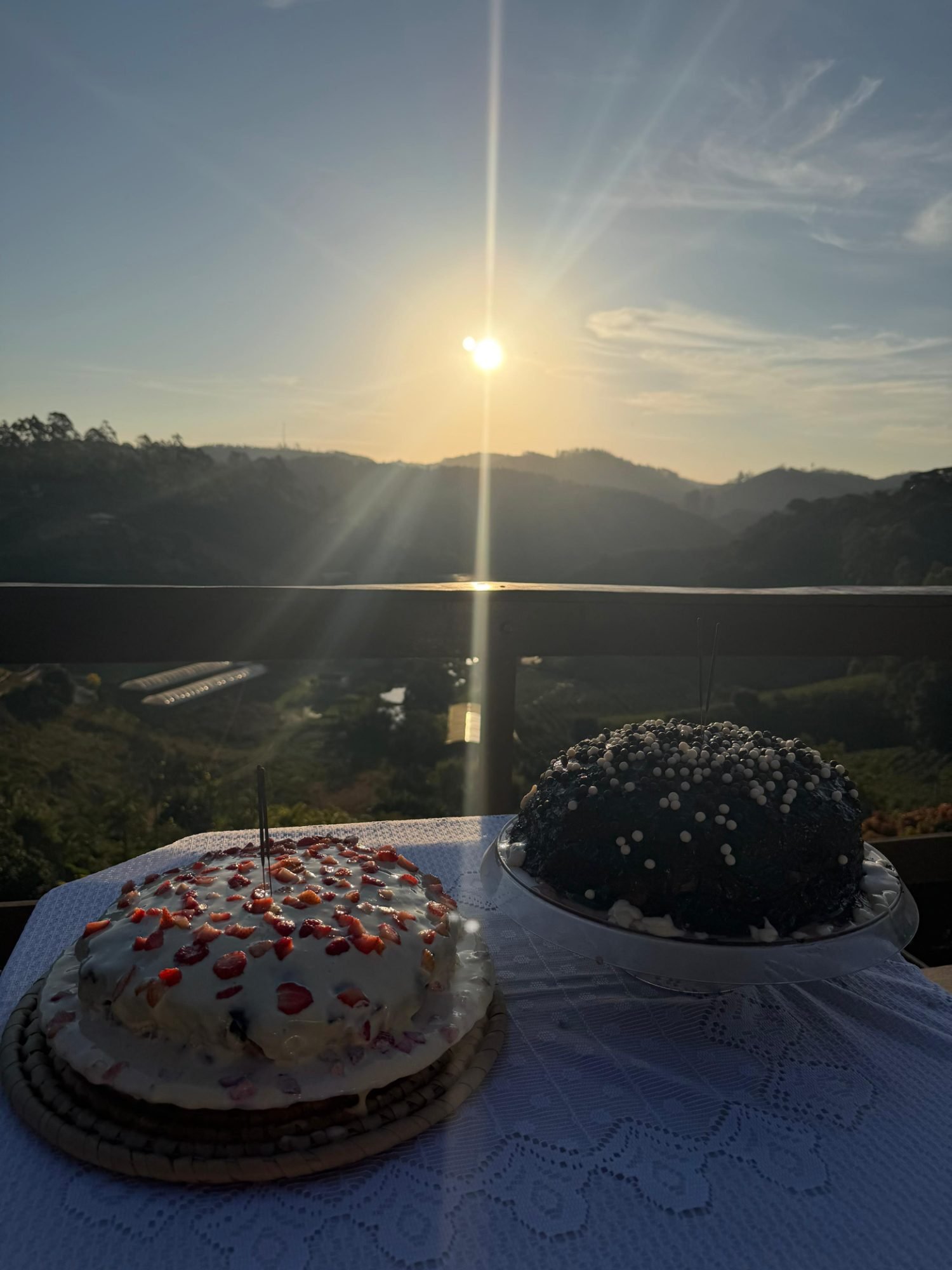 Dois bolos de aniversário na varanda com o sol se pondo
