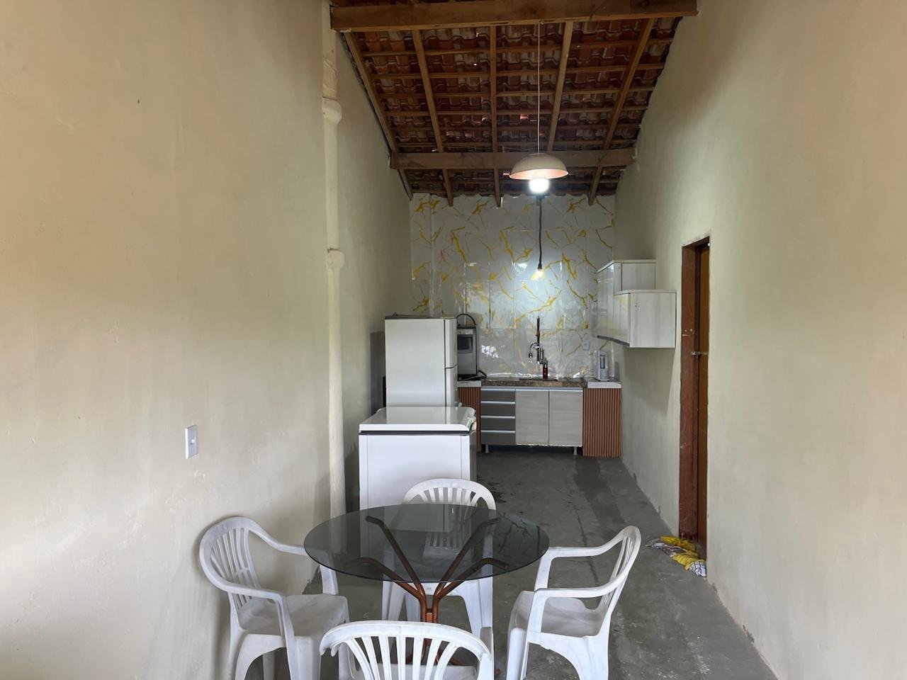 Cozinha coletiva com geladeira, pia e mesa