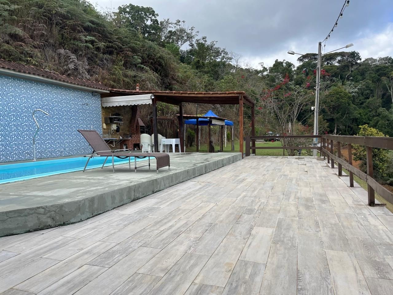 Deck de madeira, piscina e a mata ao fundo