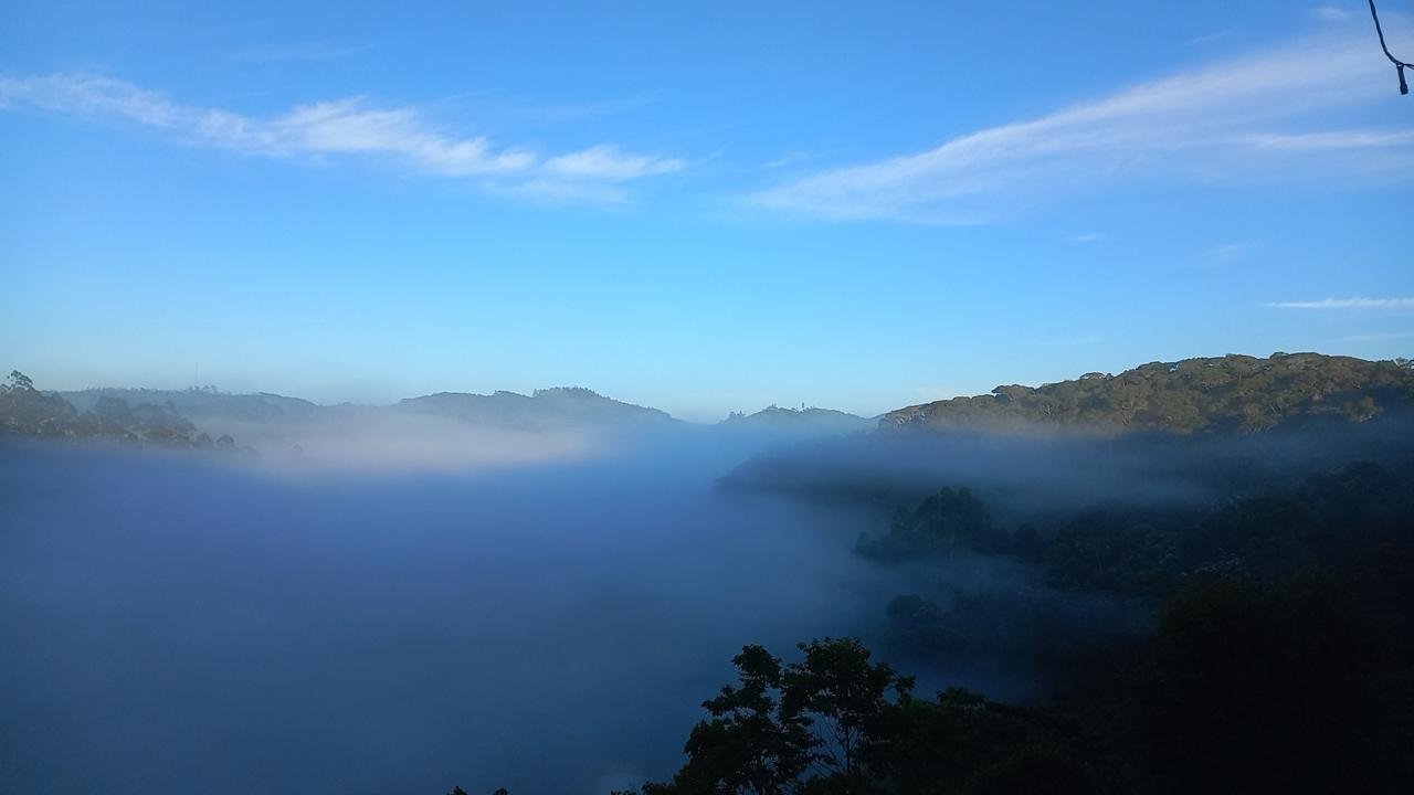 Mar de neblina azul preenchendo o vale ao amanhecer