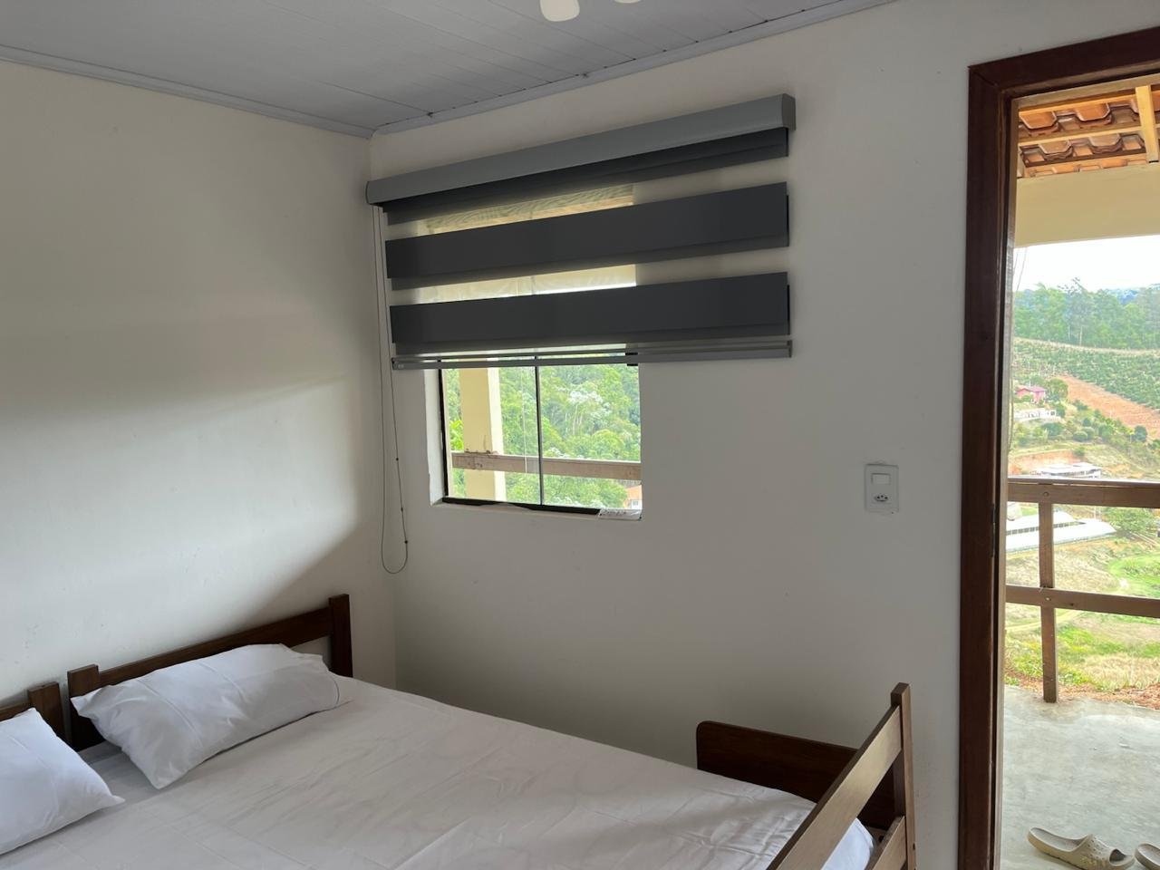Quarto com suíte, cama de casal e janela com vista